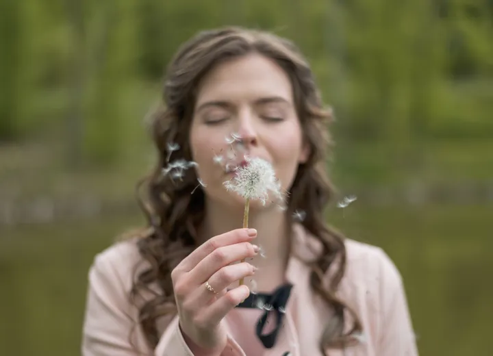 Osoba siedząca przy oknie w spokojnym, refleksyjnym ujęciu.