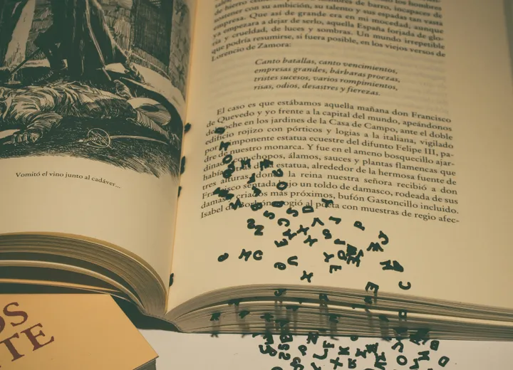 Otwarta książka z rozsypanymi literami